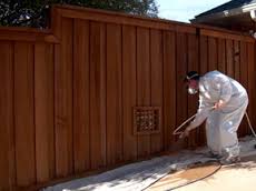 Shambaugh painting spraying finish on this bettendorf fence